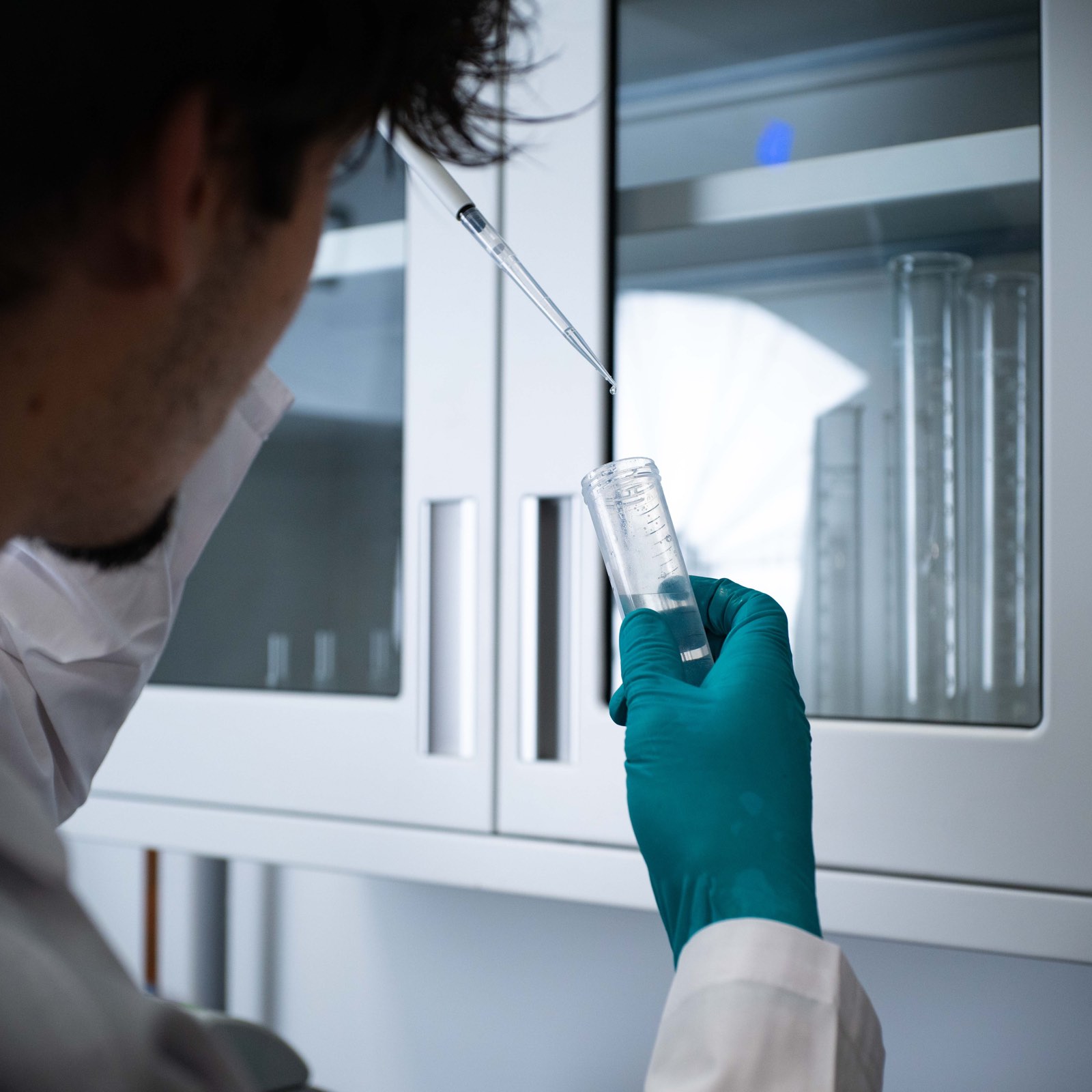 Laboratory researcher examining a clear sample tube