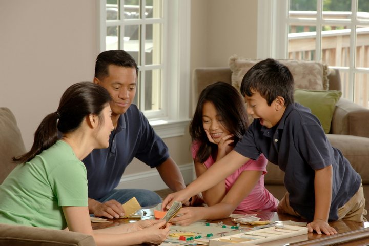 A family playing a board game around a table
